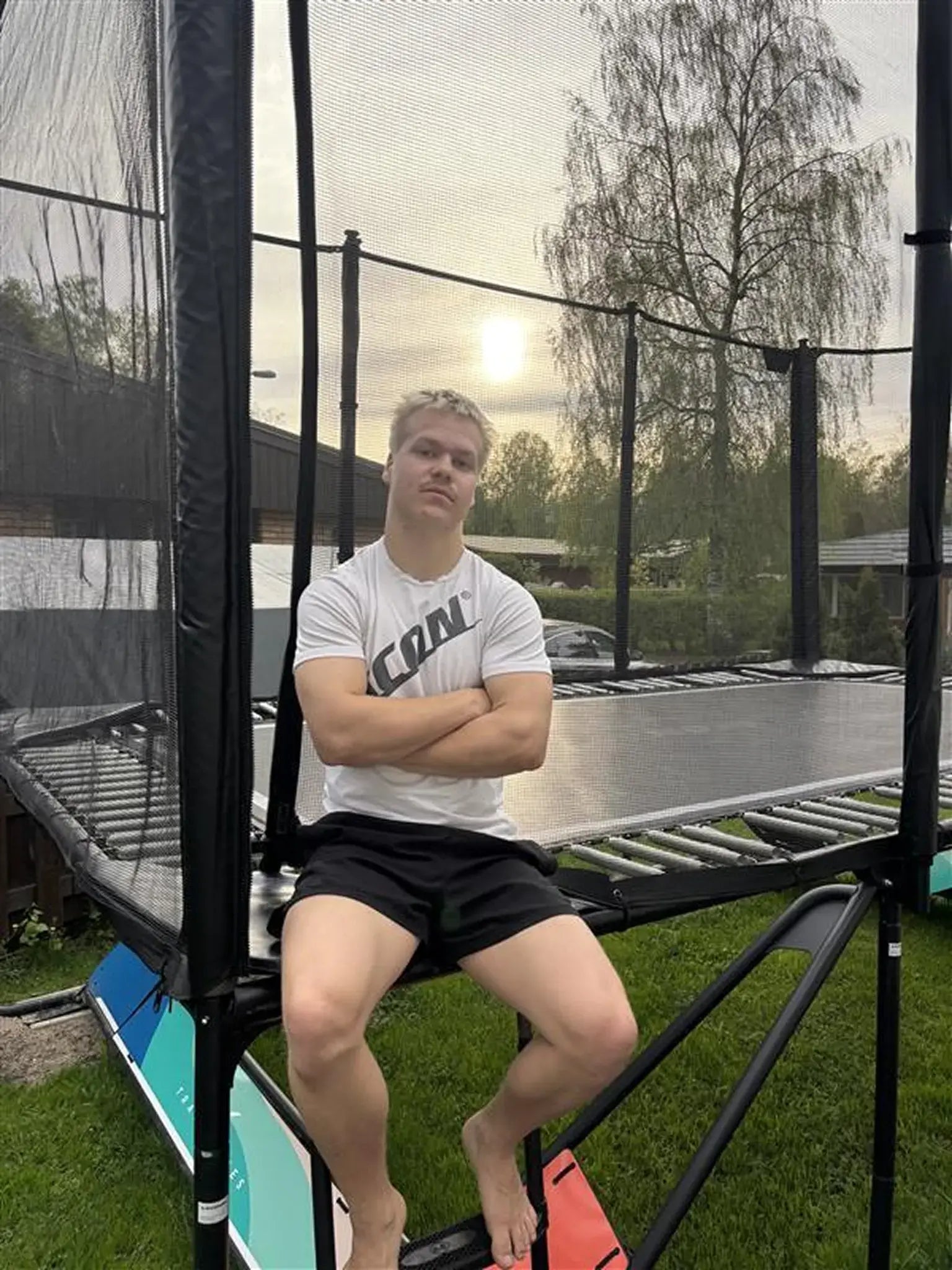 Trampoline athlete Leevi Valtonen sitting on an Acon trampoline.