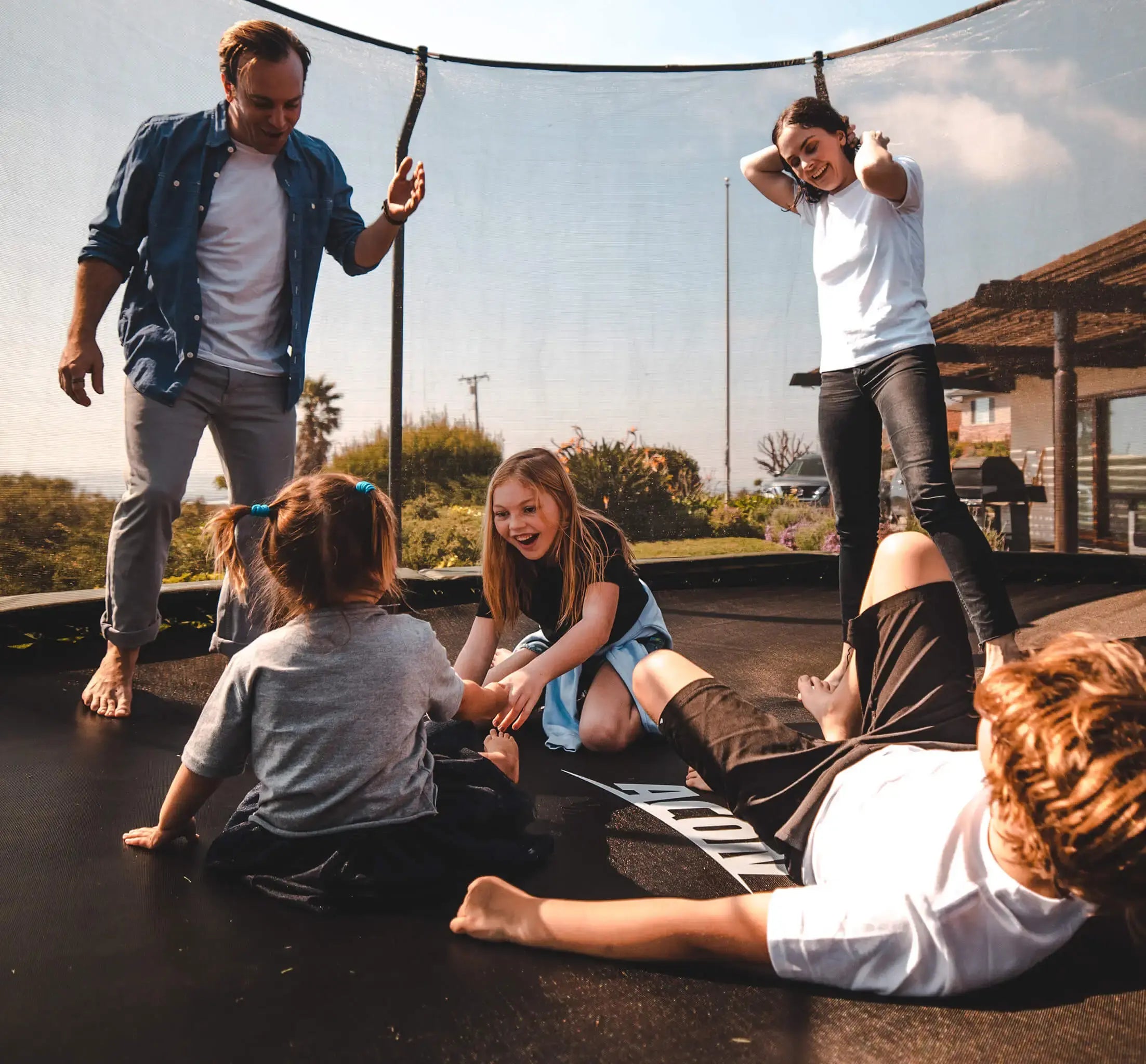 Father, mother and three children playing on an Acon trampoline.