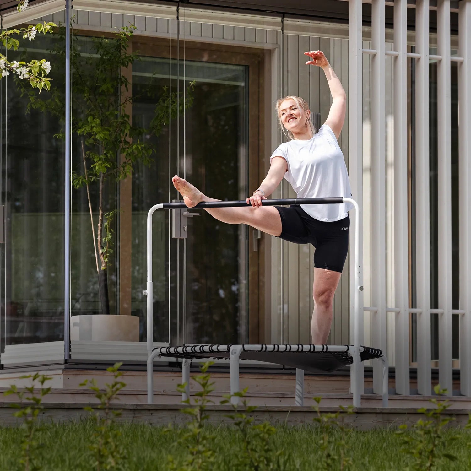 Fit 44in Round Rebounder with Balance Handlebar supporting outdoor stretches on the patio, Canadian setting.