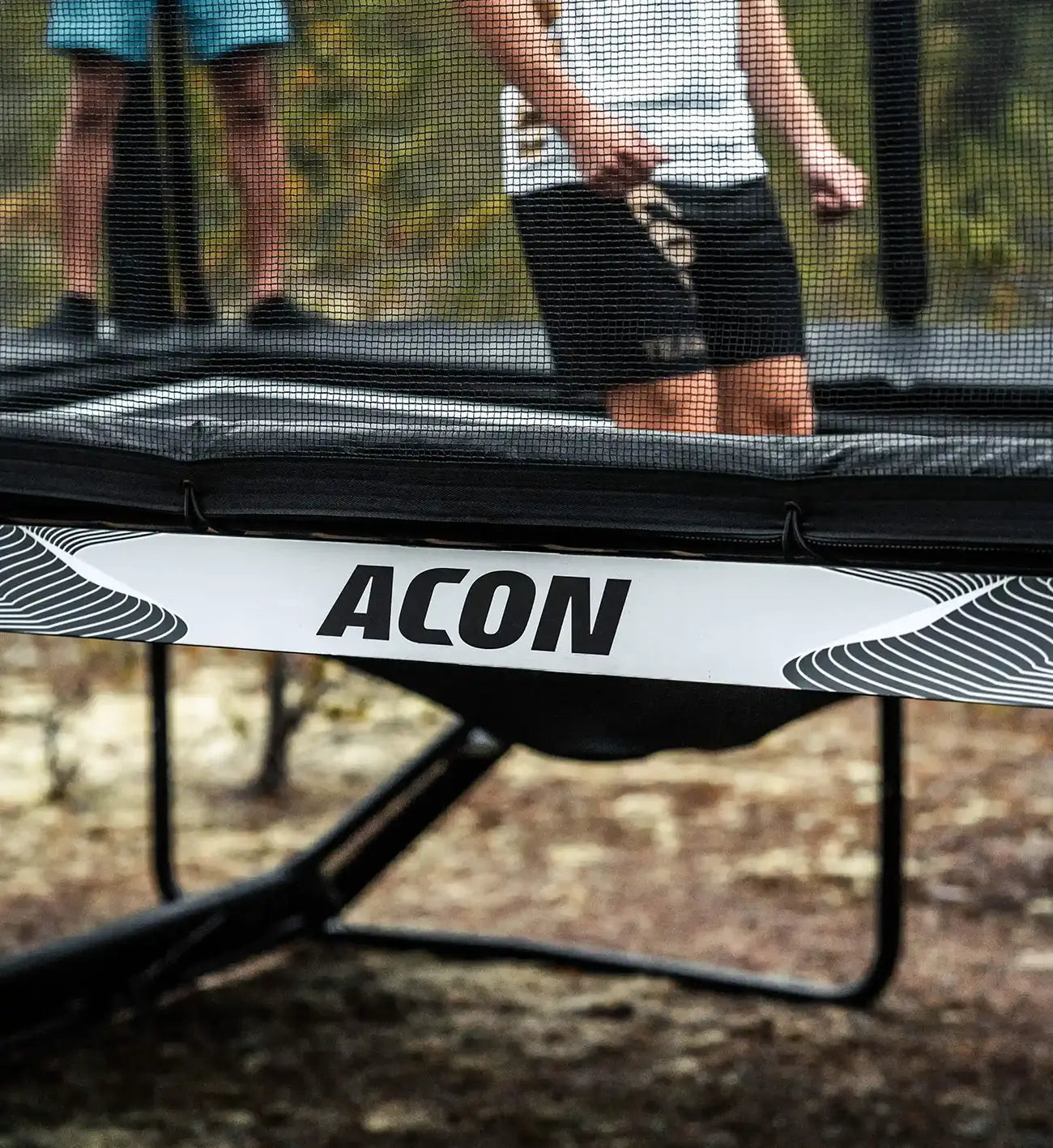 A jumper's feet on Acon X Trampoline during the descent phase.