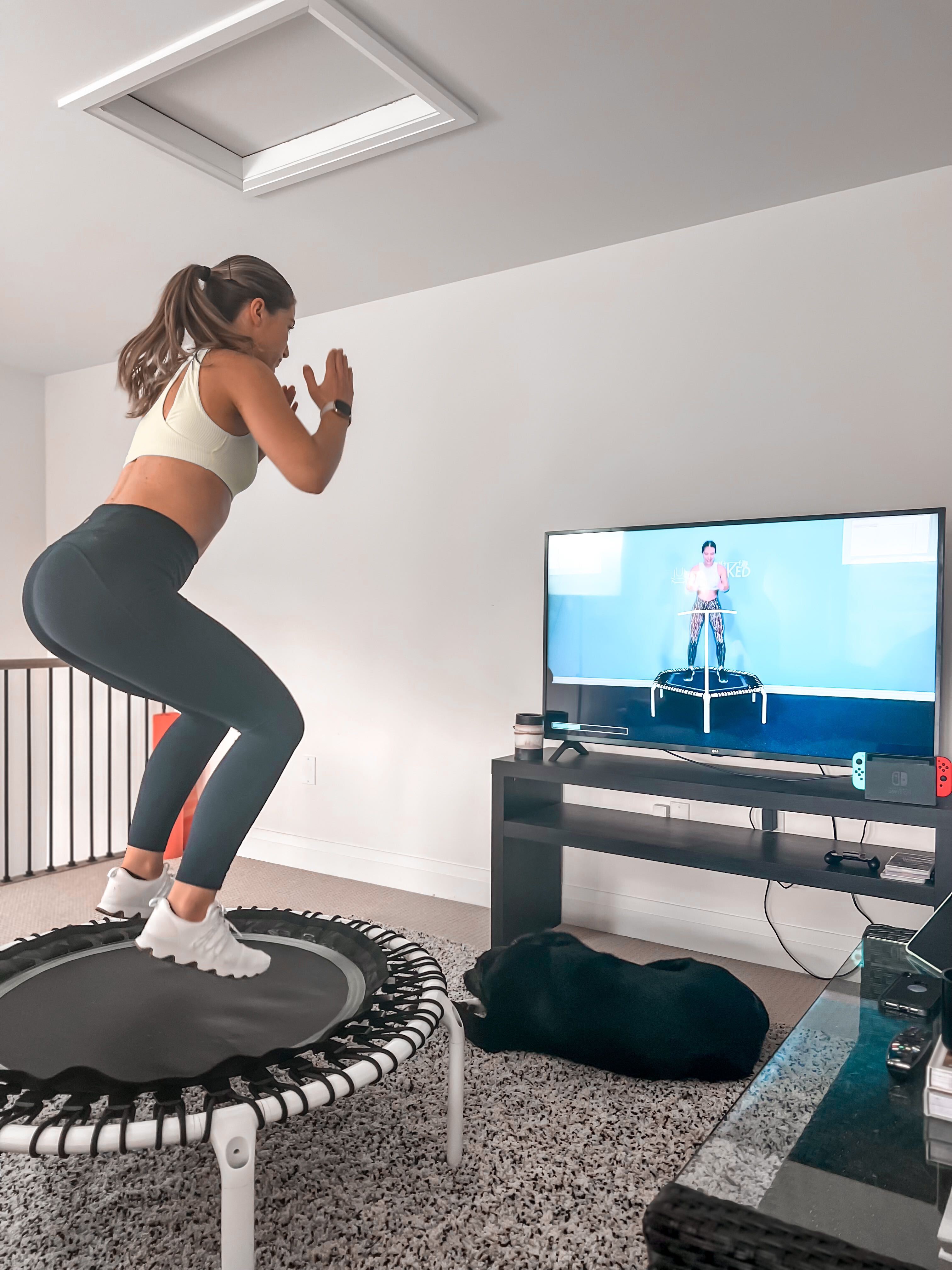 A woman doing a rebounder workout on an ACON rebounder