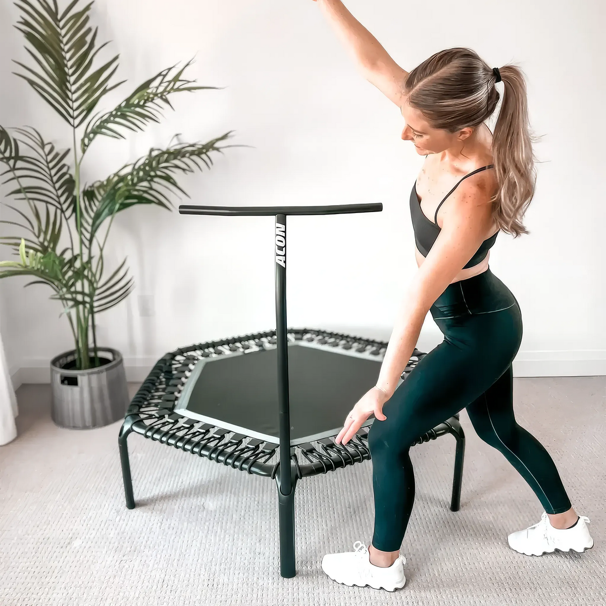 A trampoline fitness instructor Sydney posing with ACON rebounder trampoline.