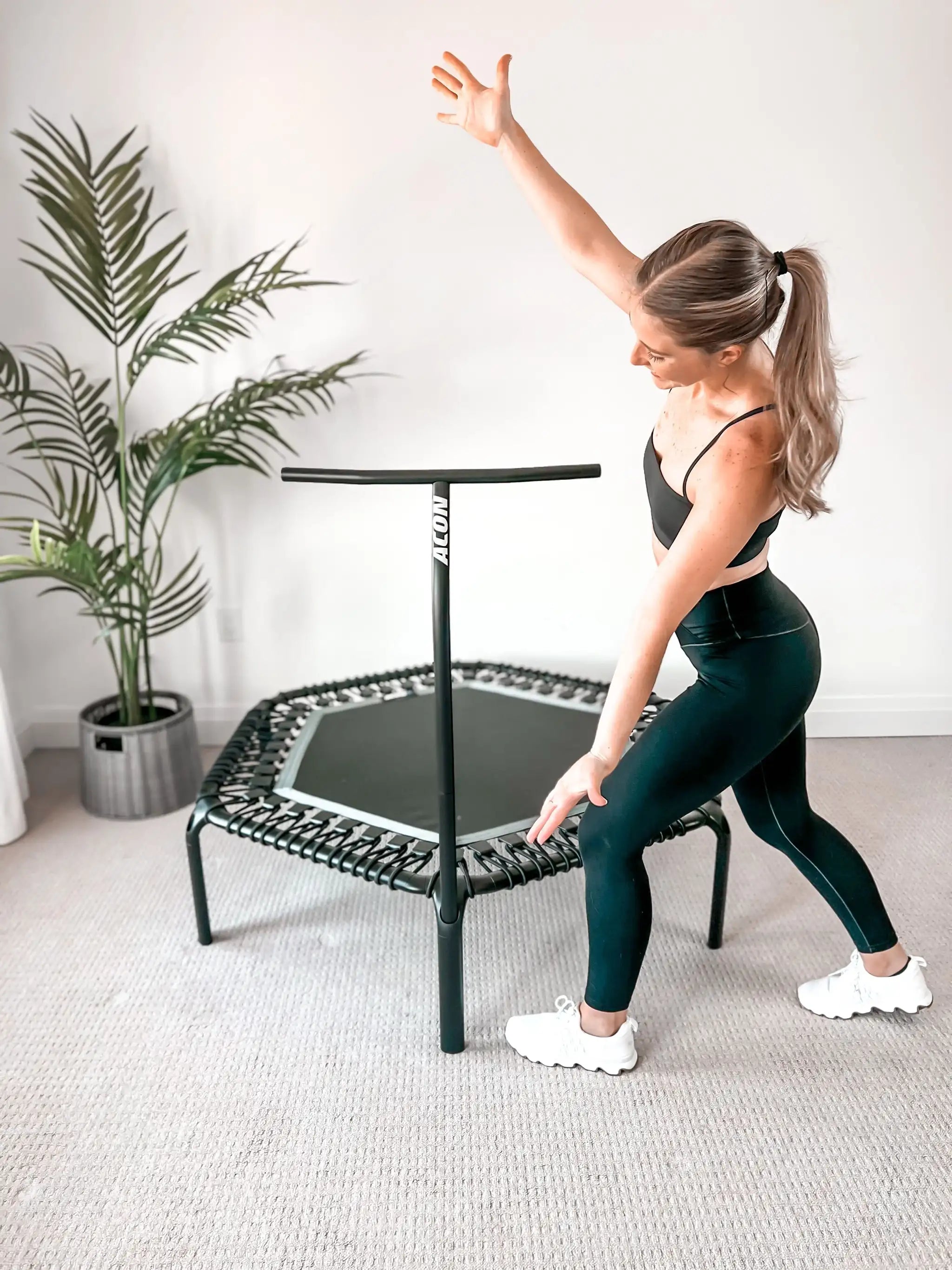 A trampoline fitness instructor Sydney posing with ACON rebounder trampoline.