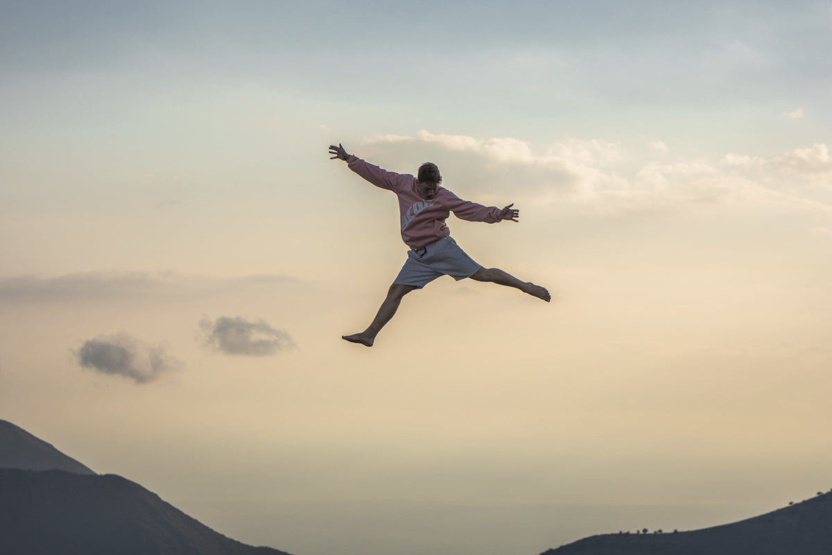 Man jumping wearing the ACON Sweatshirt Pink.