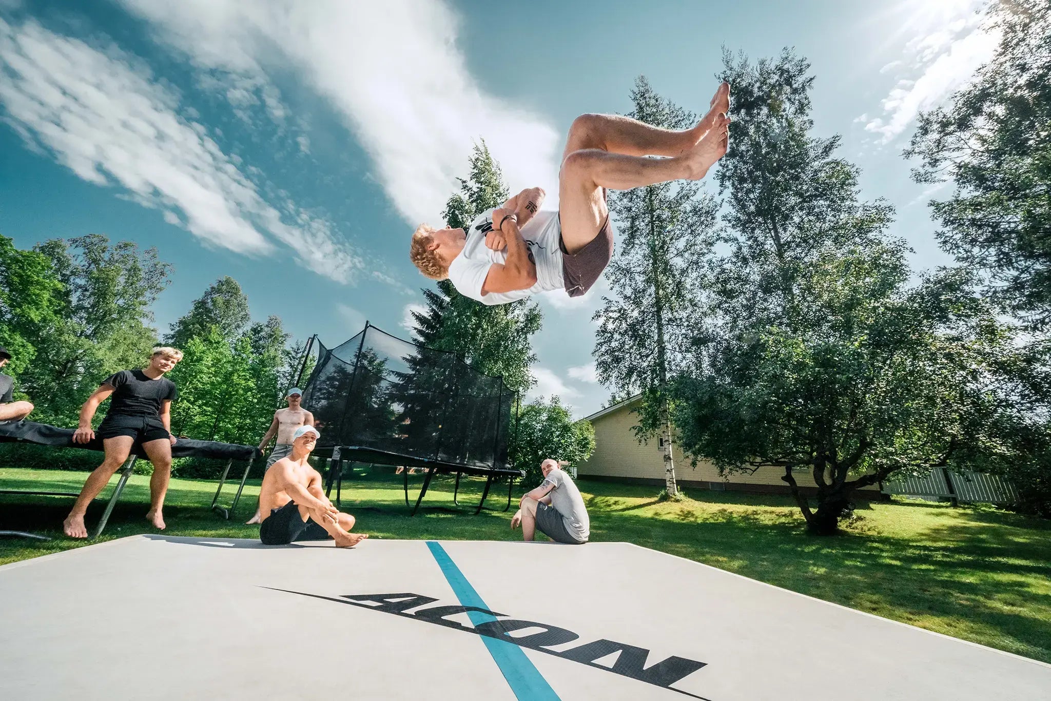 Gymnast performing a backflip on an ACON Airtrack during outdoor gymnastics training.