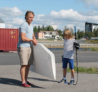A kid and Mikael Granlund holding Acon shooting pad