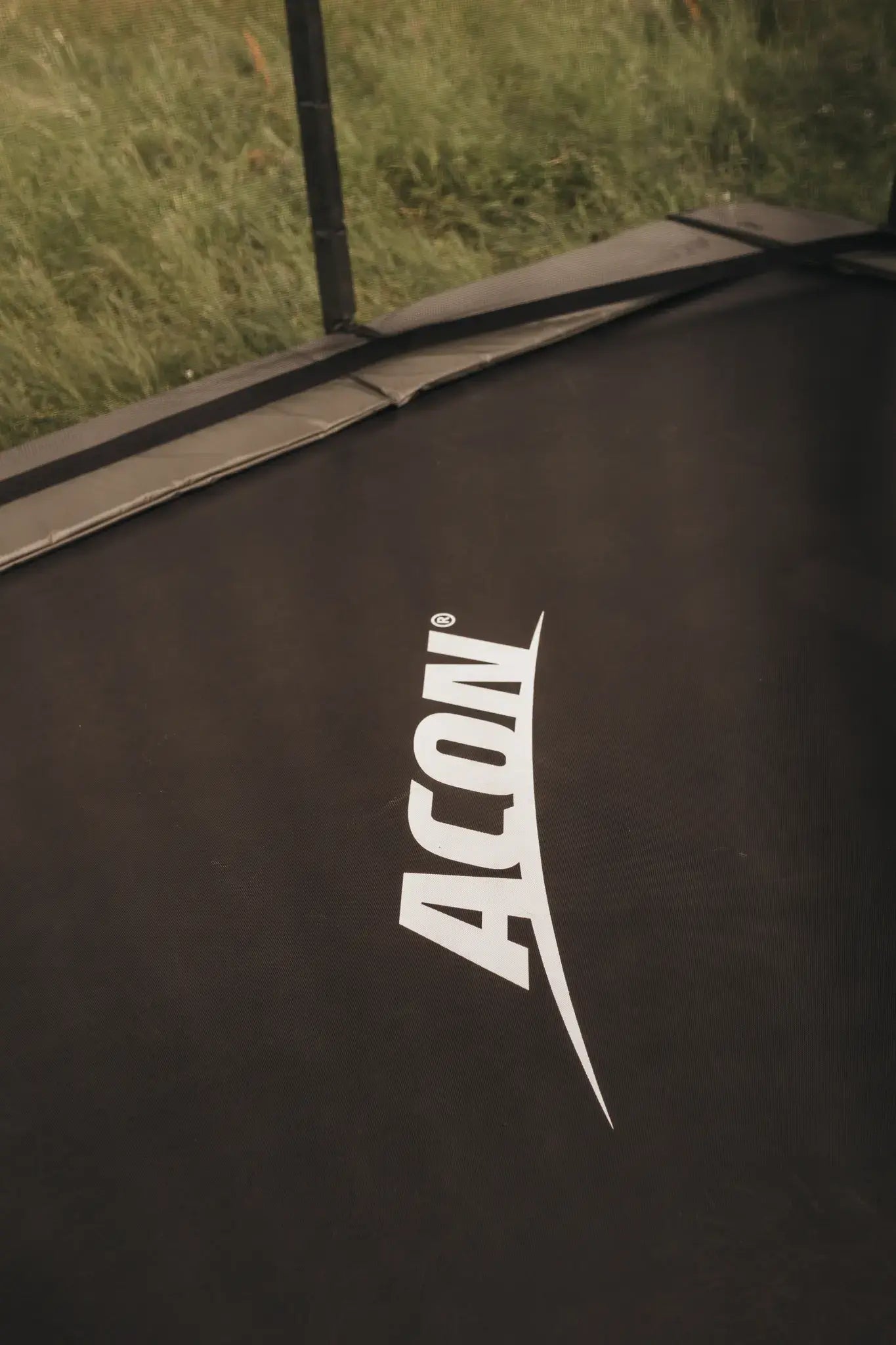 Close up picture of a rectangular Acon trampoline with safety net. 