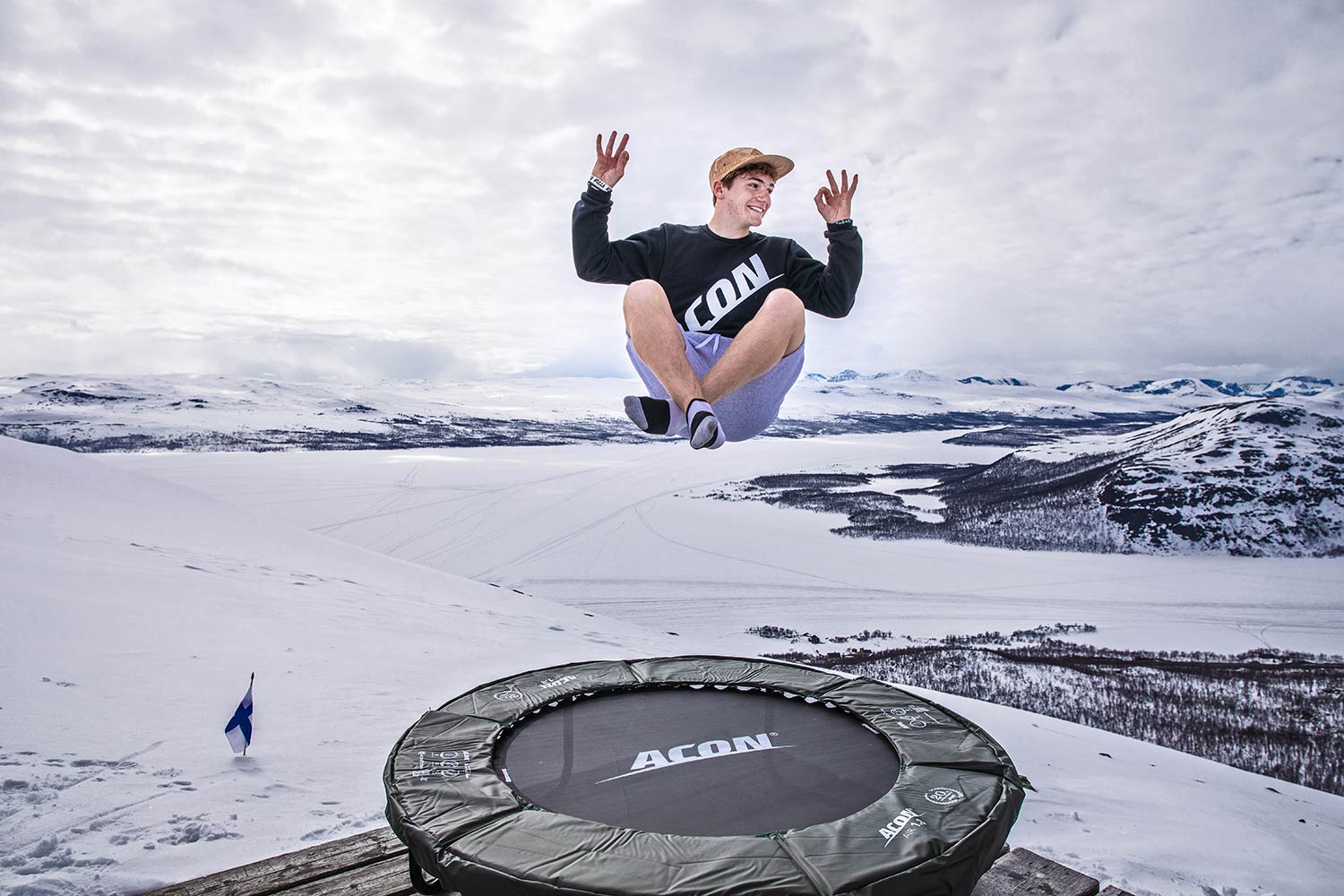 A guy jumping on a trampoline outdoors during winter