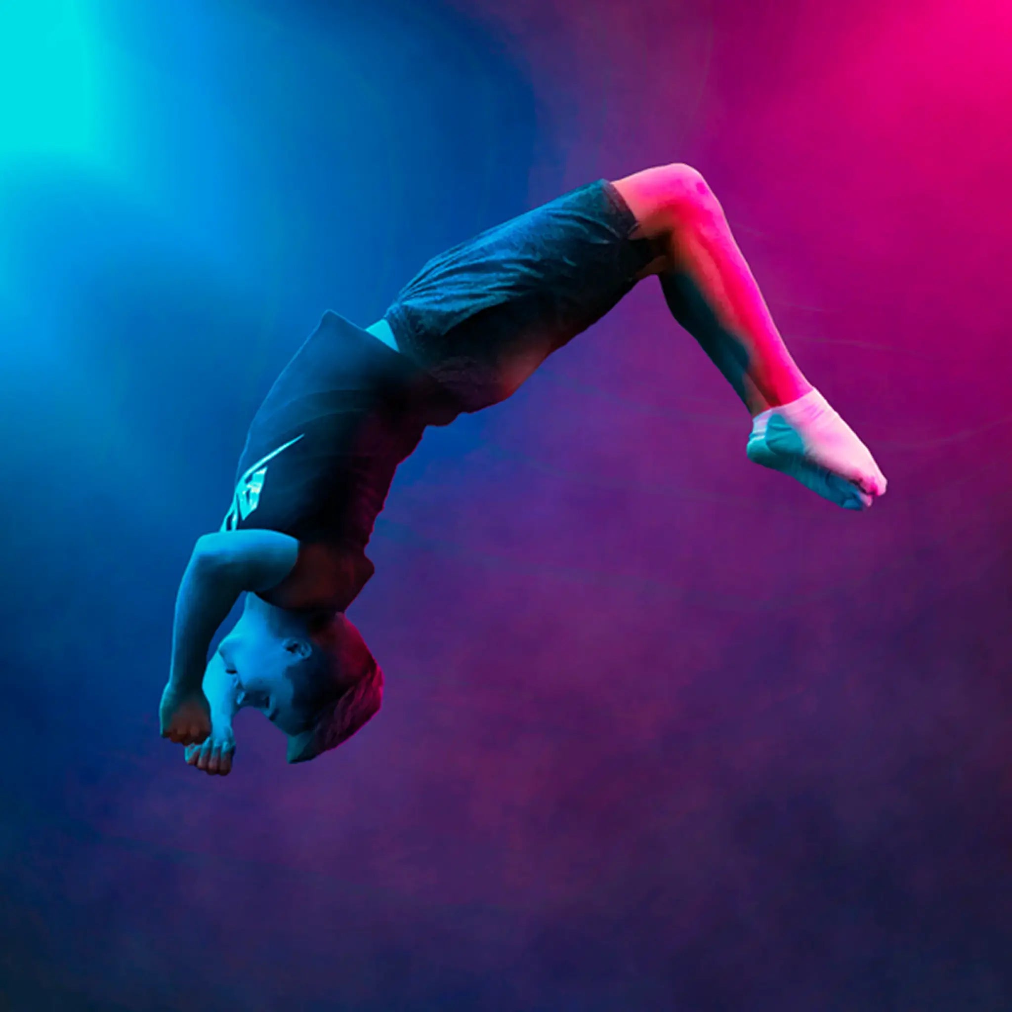 Markku Keski-Oja, Acon's Brand Ambassador, performing a backflip midair under dramatic blue and pink lighting.