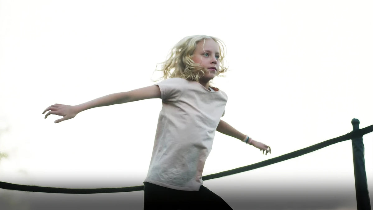 A girl jumping on an Acon trampoline with a focused look.