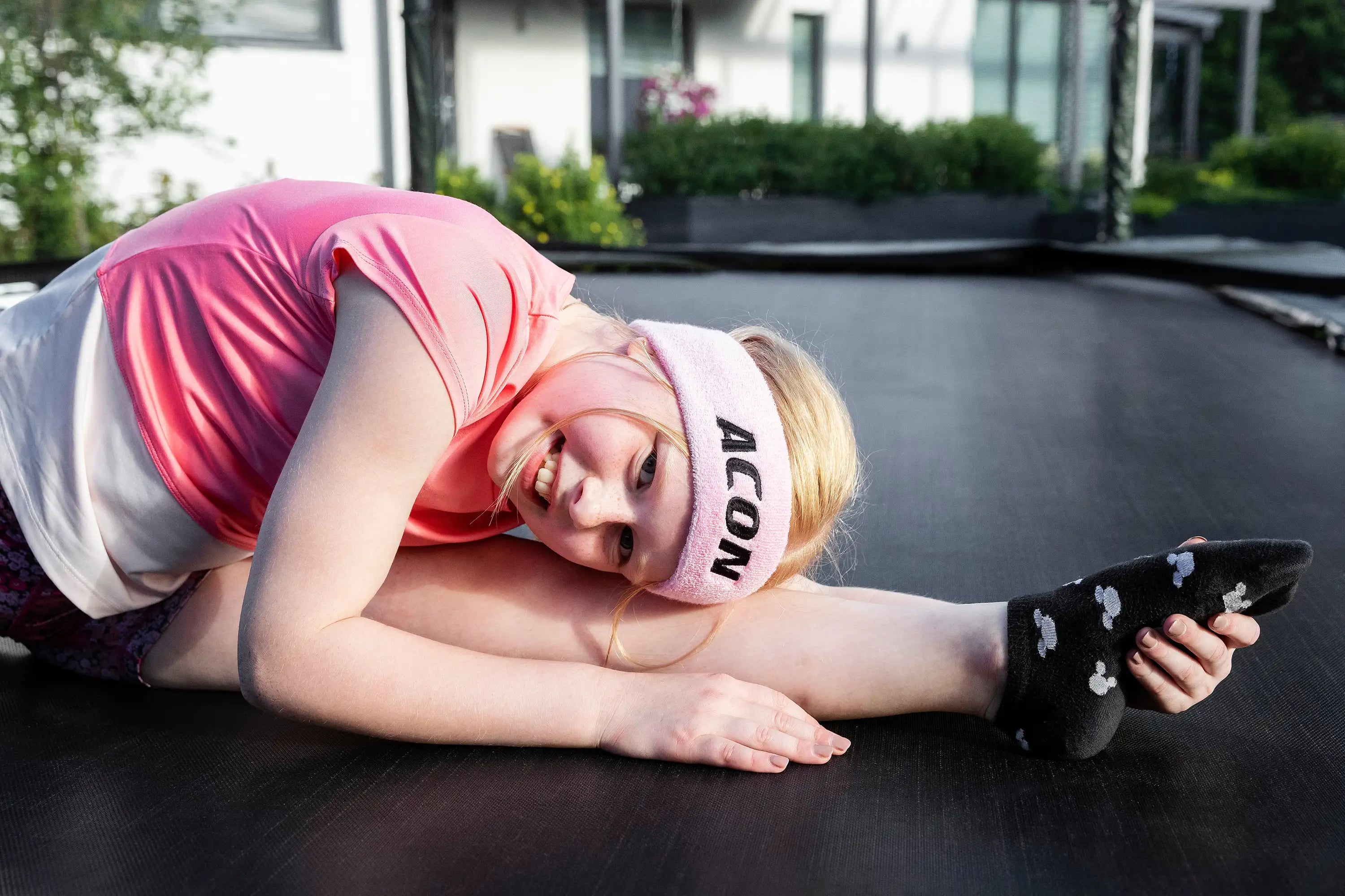 Close up image of a gymnastic stretching on a trampoline.