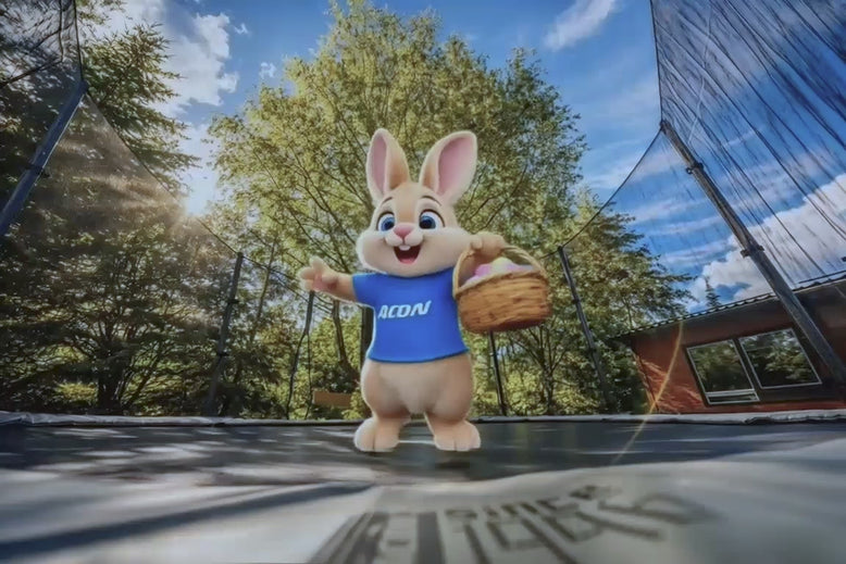 Looping video of an AI‑based bunny character in a blue Acon shirt bouncing on an Acon trampoline while holding a basket of Easter eggs, repeating the joyful motion.