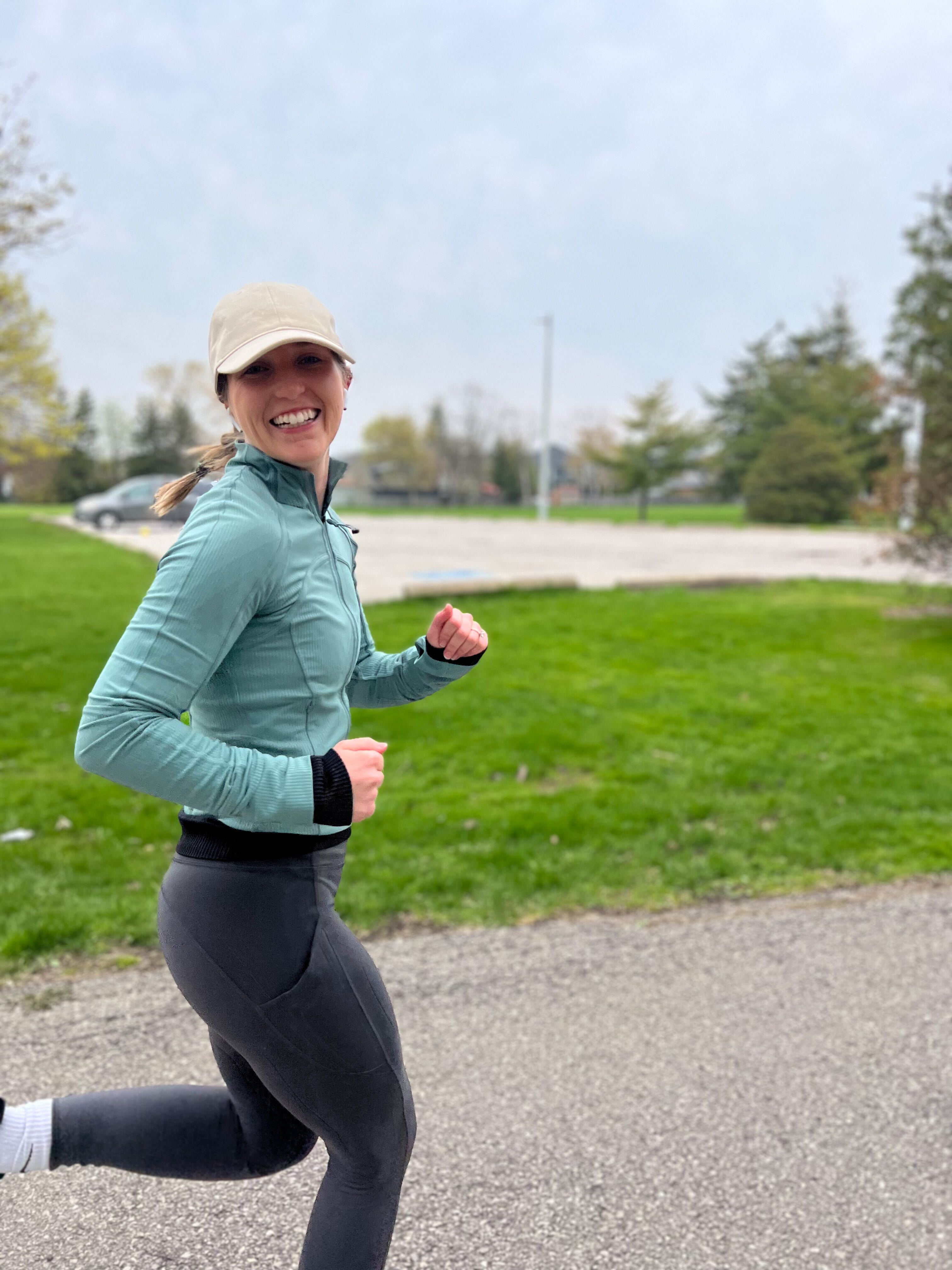 A woman running outdoors with a smile on her face