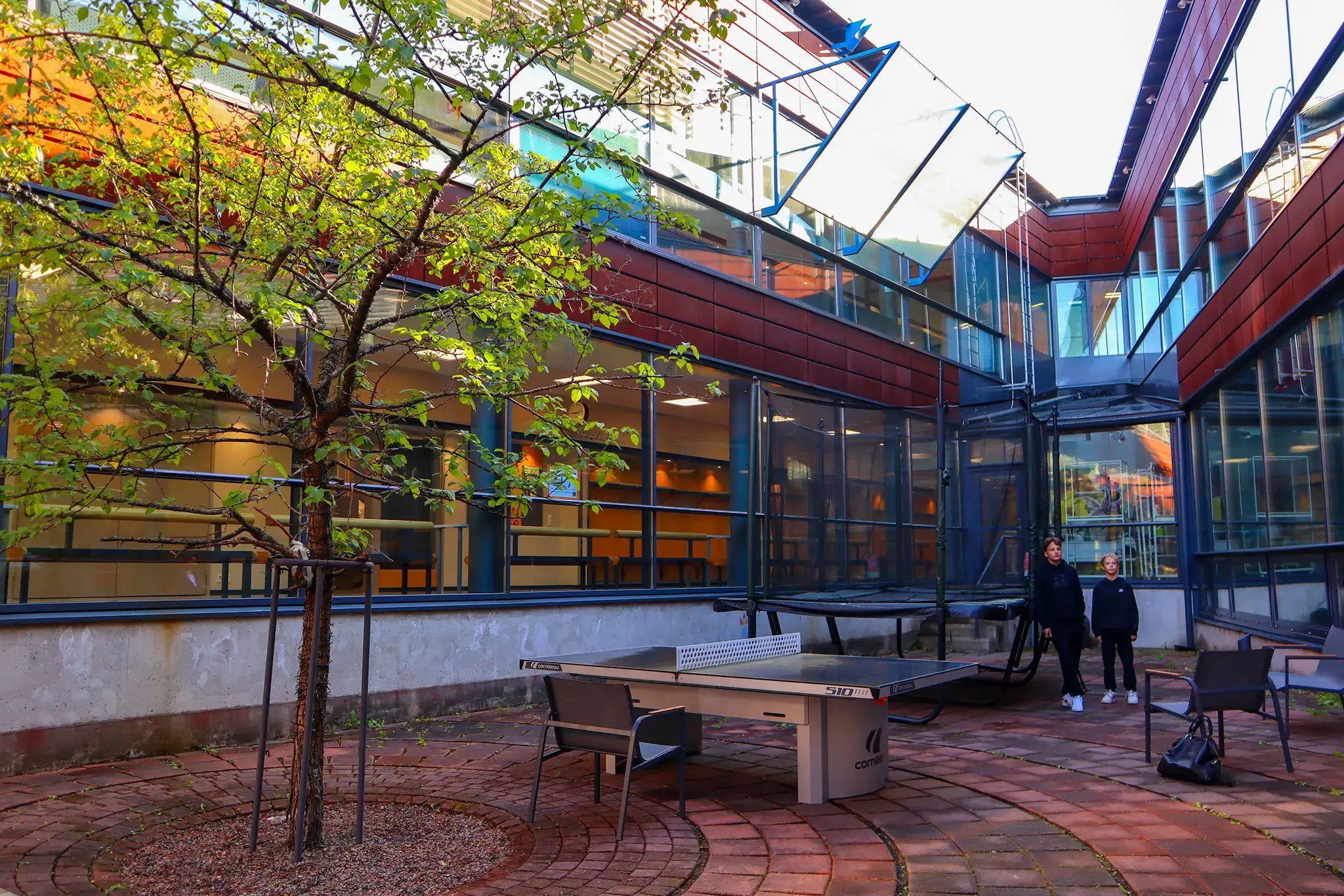 Two boys in Kaakkuri School standing outside next to the Acon trampoline. 