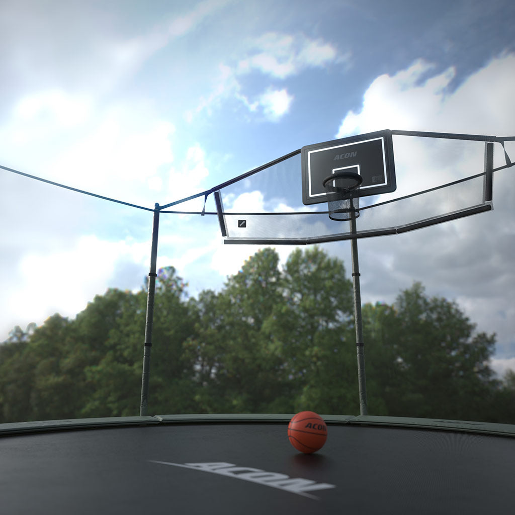 Outdoors image of an Acon Basketball Hoop Back Net mounted on a round trampoline