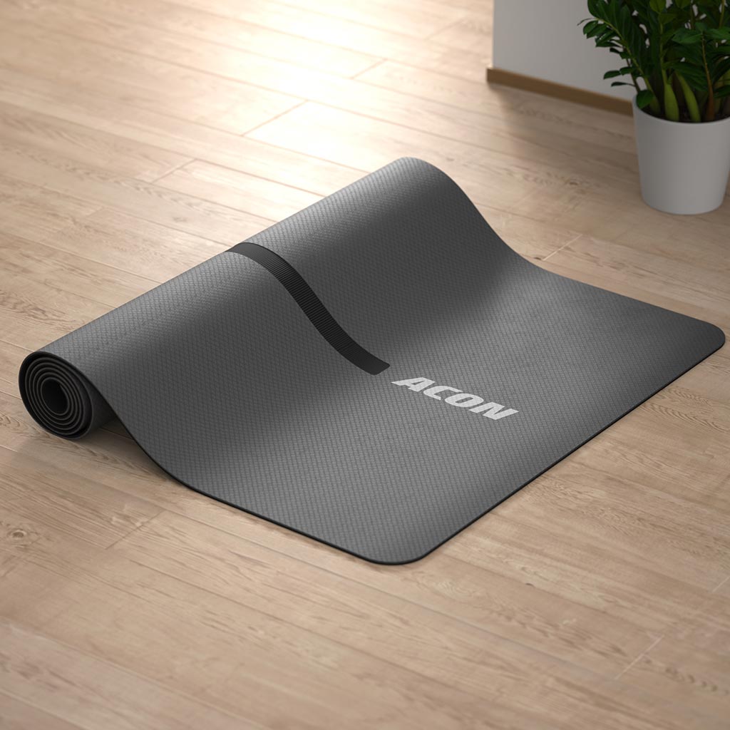 Image of Acon Eco-friendly Yoga Mat partially rolled up, lying on a wood yoga studio floor.