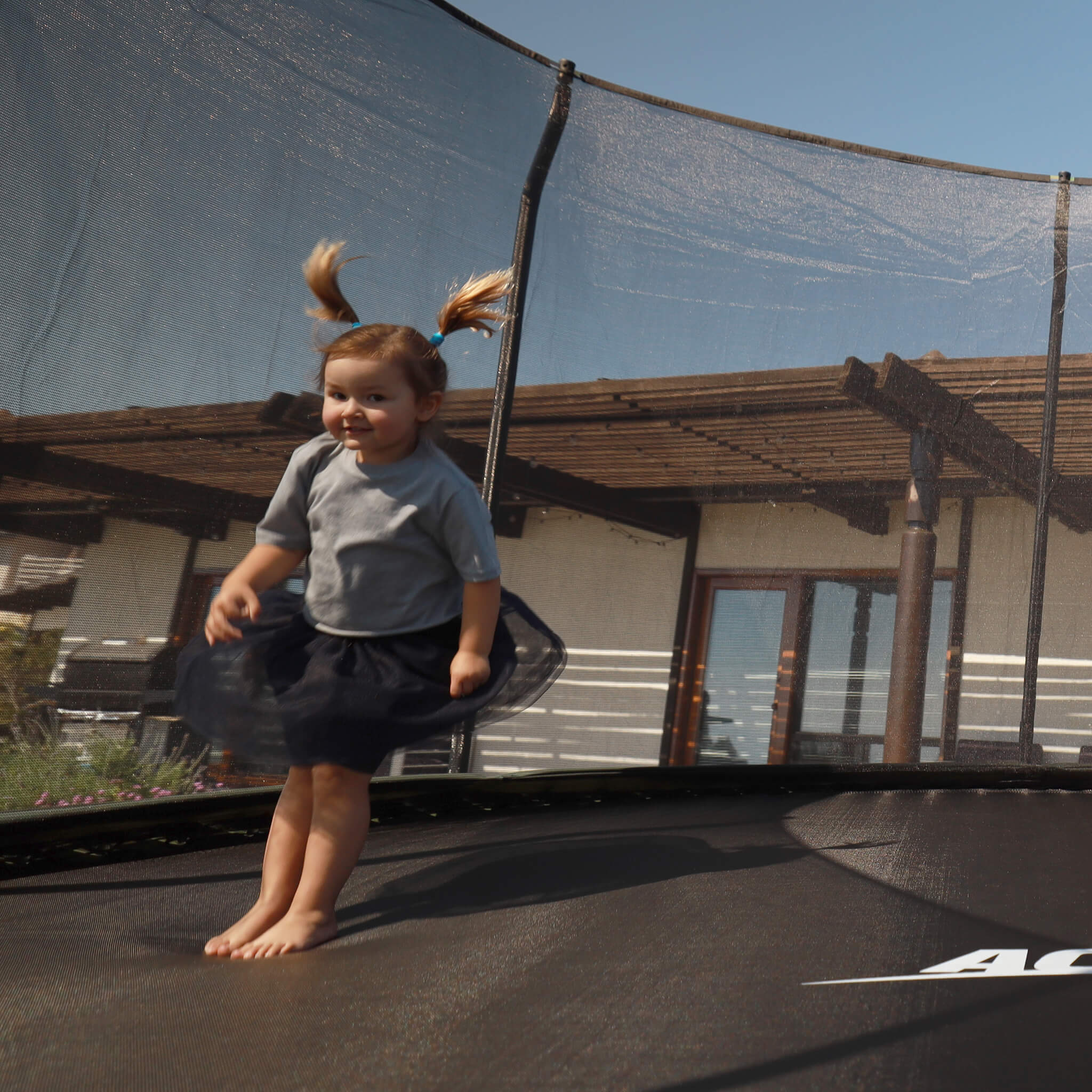 A small child jumps on an Acon trampoline.